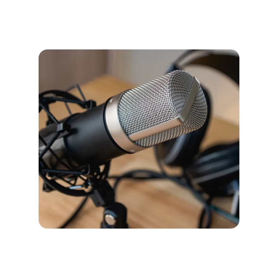 Microphone on a stand next to a pair of headphones